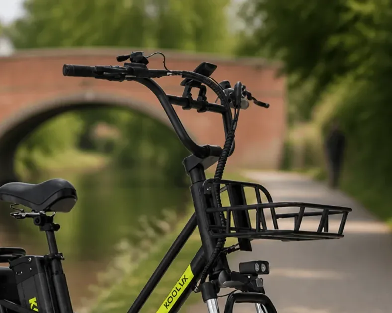 Vélo électrique Koolux en atelier, cadre et batterie visibles, outils de montage à proximité